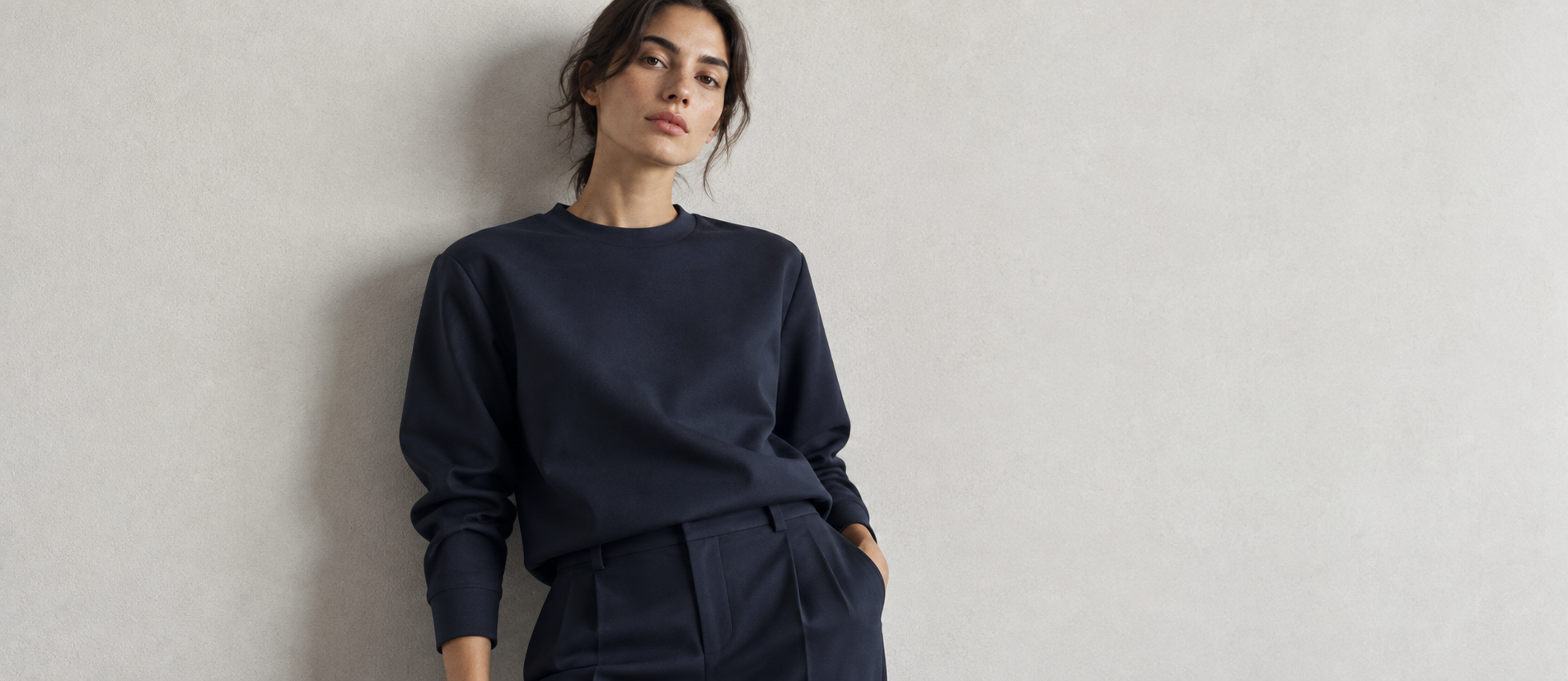 Model wearing a navy pullover against a light wall